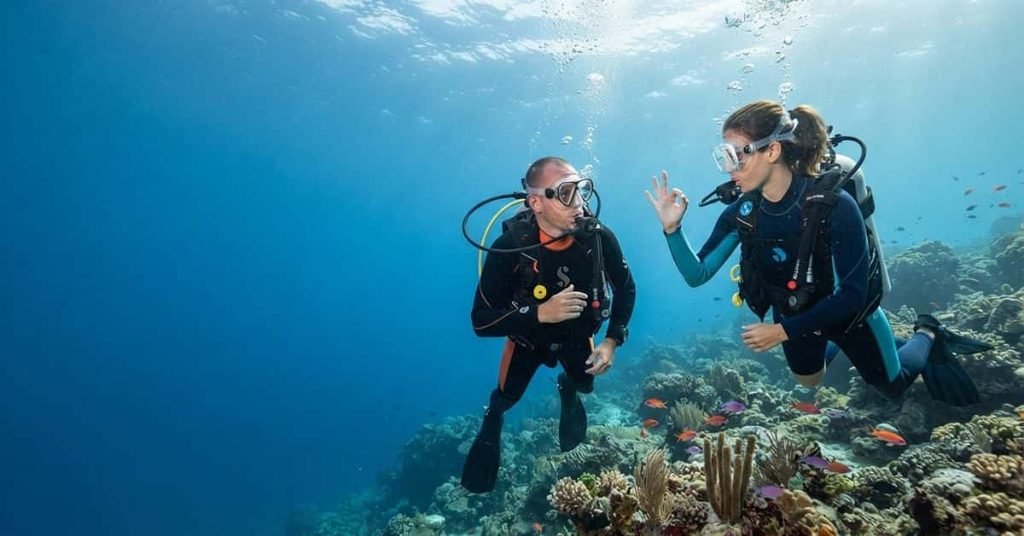 Scuba divers communicating underwater using hand signals
